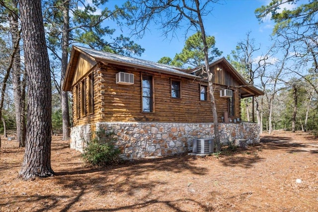 view of property exterior featuring central AC unit and log siding