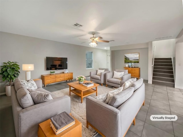 living room with ceiling fan, light tile patterned floors, visible vents, baseboards, and stairs