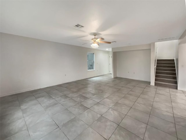 spare room featuring stairs, ceiling fan, visible vents, and baseboards