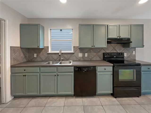 kitchen featuring under cabinet range hood, a sink, backsplash, black appliances, and green cabinetry