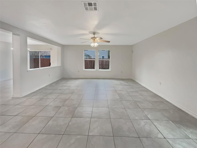 spare room with light tile patterned floors, baseboards, visible vents, and a ceiling fan