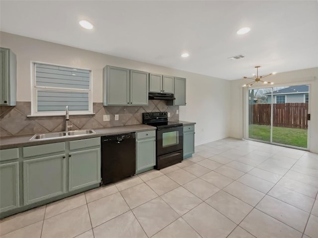 kitchen with visible vents, under cabinet range hood, black appliances, green cabinets, and a sink