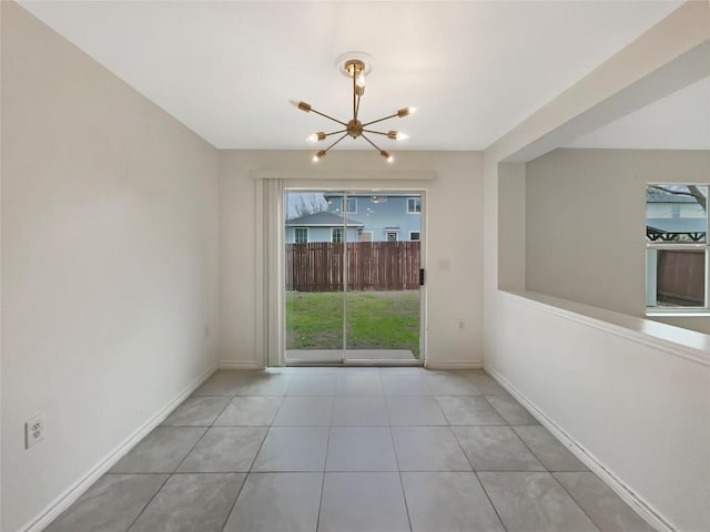 unfurnished room featuring a chandelier, tile patterned flooring, and baseboards