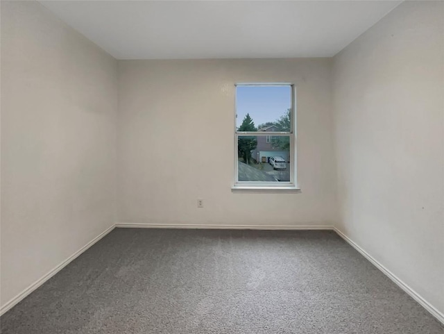 spare room with carpet and baseboards