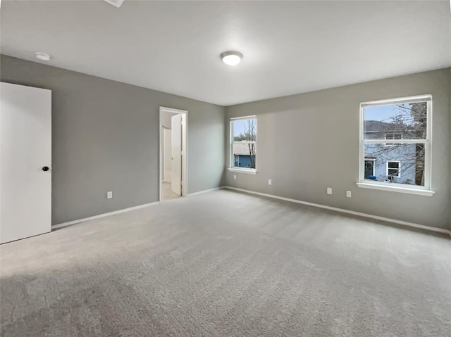 unfurnished room with carpet and baseboards