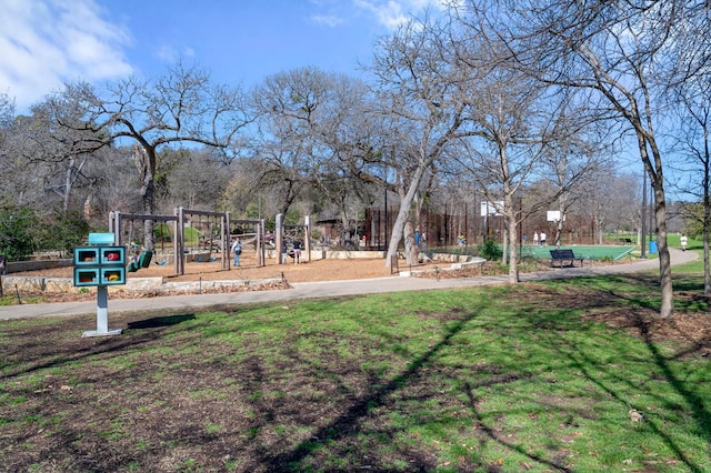 view of home's community featuring playground community and a yard