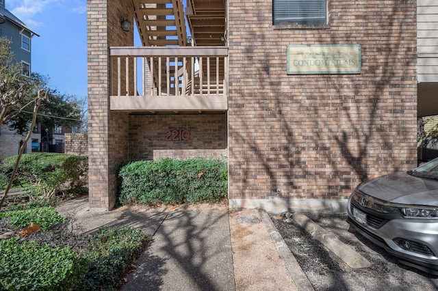 exterior space with a balcony and brick siding