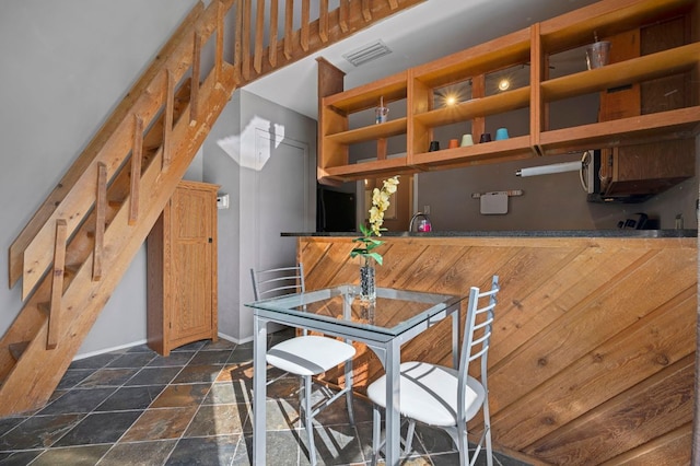 dining area with stone finish floor and visible vents