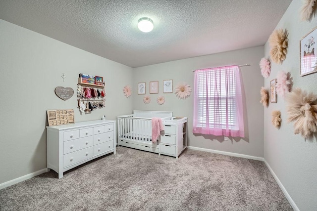 112 Quarton Dr, Hutto, TX 78634 - bedroom with carpet, a textured ceiling, a nursery area, and baseboards