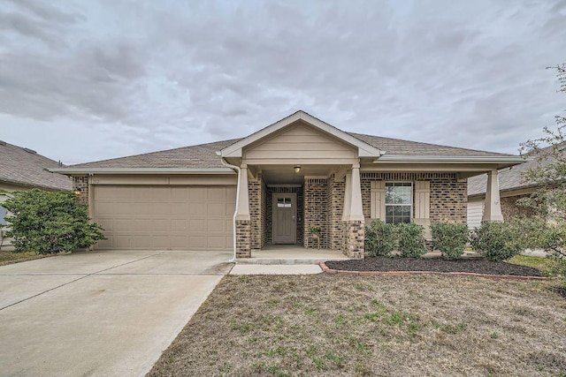 view of front of home featuring a garage, concrete driveway, and brick siding