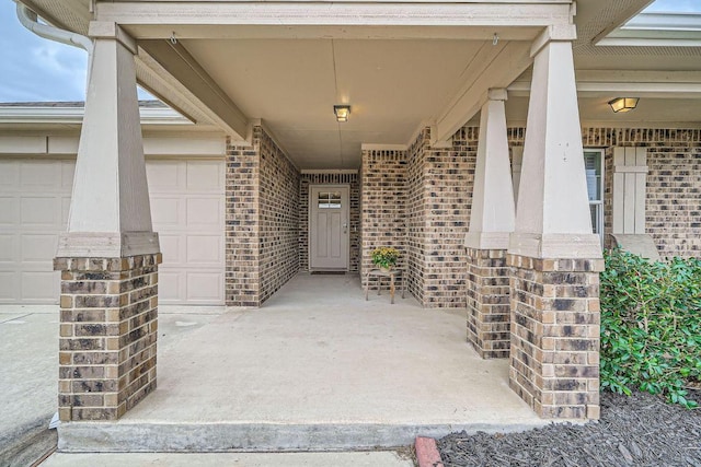 property entrance with a garage and brick siding