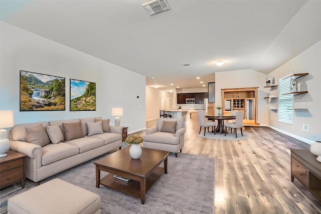 112 Quarton Dr, Hutto, TX 78634 - living area with light wood-style floors, baseboards, and vaulted ceiling
