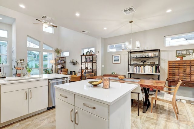 kitchen with a sink, visible vents, white cabinets, and dishwasher