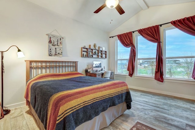 bedroom featuring multiple windows, lofted ceiling with beams, and wood finished floors