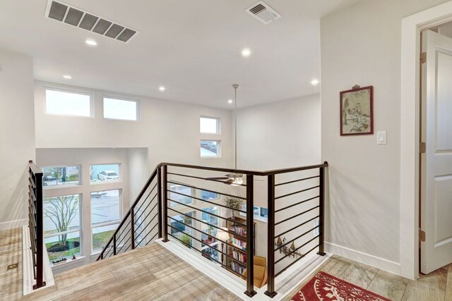 corridor with visible vents, recessed lighting, an upstairs landing, and baseboards