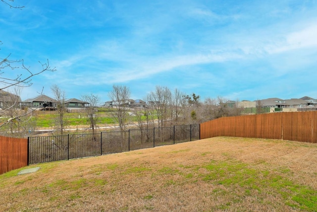 view of yard with a fenced backyard and a residential view