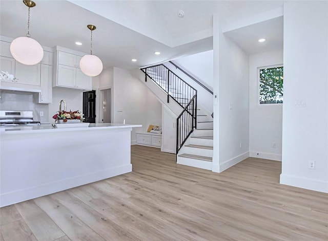 5408 Downs Dr Unit 2, Austin, TX 78721 - kitchen with stainless steel range, under cabinet range hood, light wood-type flooring, baseboards, and recessed lighting