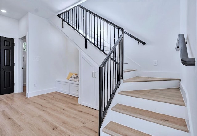 stairs with recessed lighting, baseboards, and wood finished floors