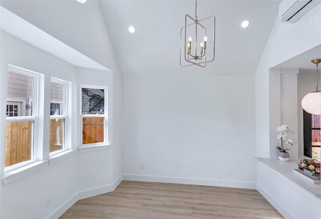 unfurnished dining area featuring a notable chandelier, recessed lighting, light wood-type flooring, a wall mounted air conditioner, and baseboards