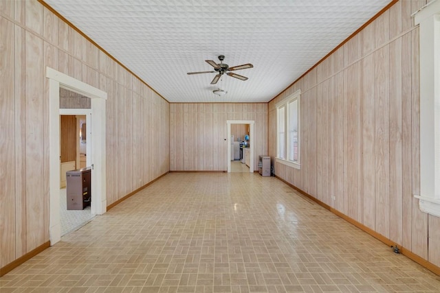unfurnished room featuring brick patterned floor, crown molding, and baseboards