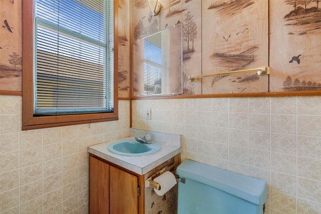 bathroom with tile walls, vanity, and toilet