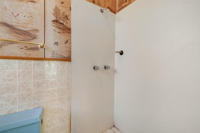 bathroom featuring toilet and tile walls