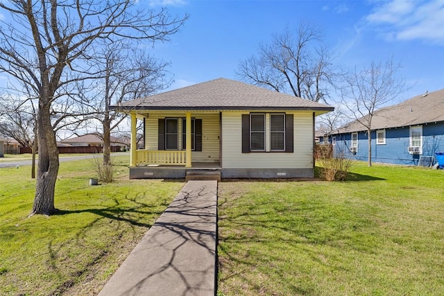 bungalow-style house featuring a front yard, covered porch, roof with shingles, and crawl space