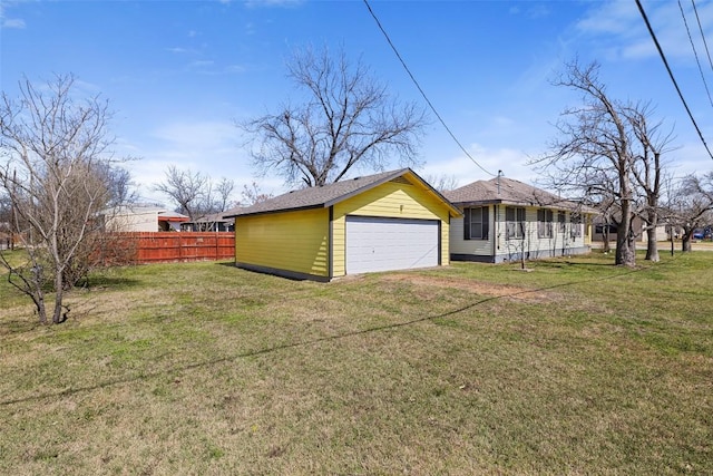 exterior space featuring a yard, fence, and a garage