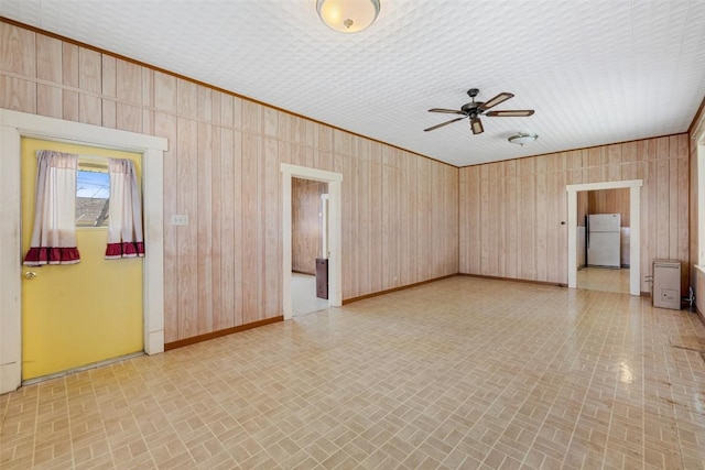 spare room featuring baseboards, ceiling fan, and brick patterned floor