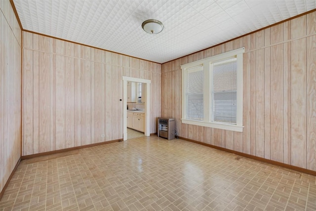 unfurnished room featuring brick patterned floor, wood walls, and baseboards