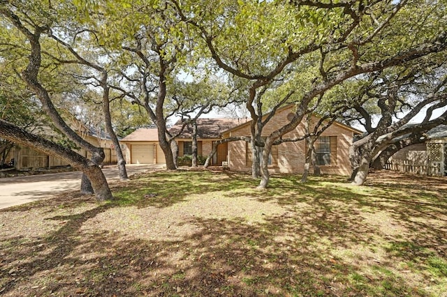 ranch-style home featuring a garage, concrete driveway, and brick siding