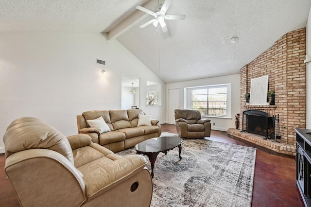 living area with beam ceiling, a fireplace, visible vents, a ceiling fan, and a textured ceiling