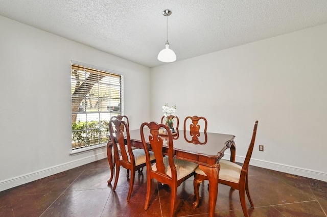 dining area featuring a textured ceiling and baseboards