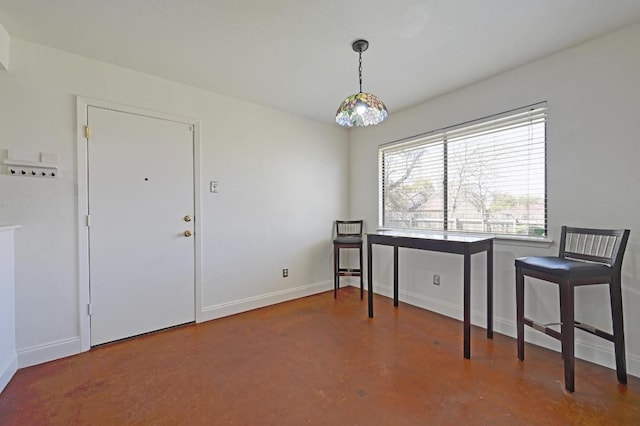 dining space with baseboards and finished concrete flooring