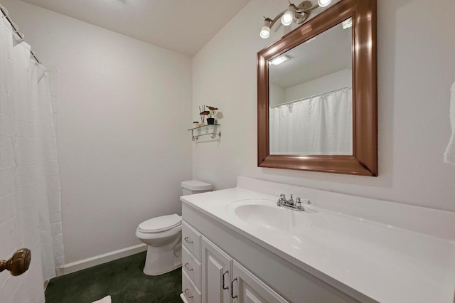 bathroom with toilet, vanity, and baseboards