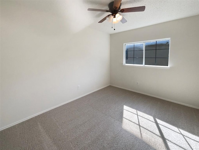 unfurnished room with carpet floors, ceiling fan, baseboards, and a textured ceiling