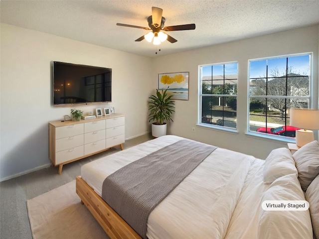 bedroom with a textured ceiling, ceiling fan, and baseboards