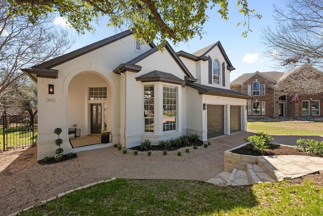 view of front facade featuring a garage, driveway, covered porch, fence, and brick siding