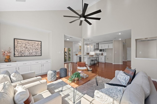 living area with a ceiling fan, baseboards, and wood finished floors