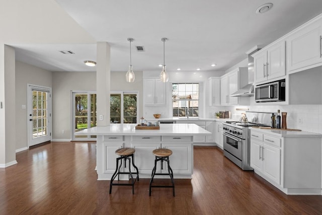 kitchen featuring stainless steel appliances, dark wood-type flooring, visible vents, light countertops, and decorative backsplash