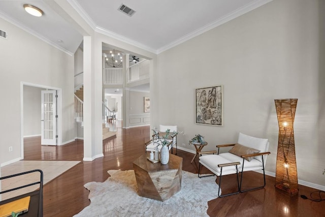 sitting room featuring ornamental molding, wood finished floors, visible vents, and stairs