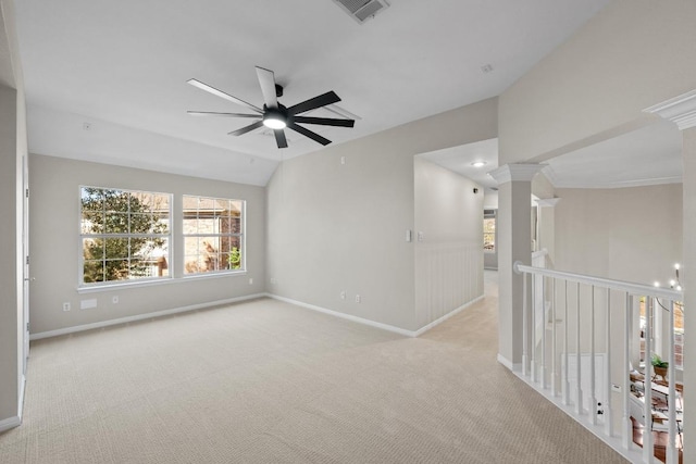 empty room featuring decorative columns, baseboards, visible vents, vaulted ceiling, and carpet flooring