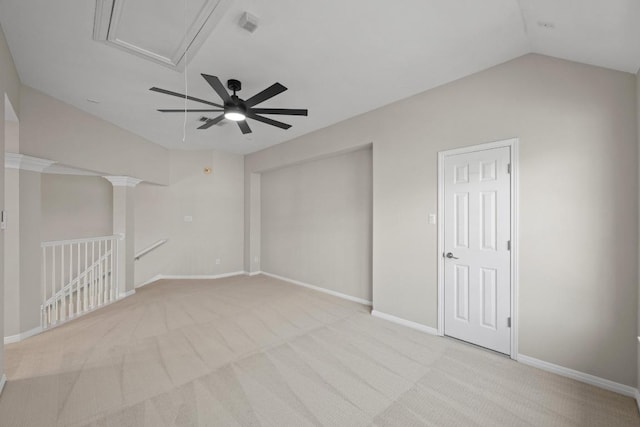 unfurnished room with lofted ceiling, attic access, baseboards, and light colored carpet