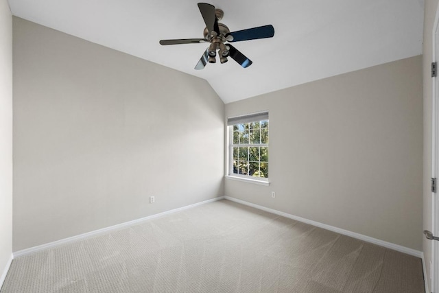 carpeted empty room with baseboards, vaulted ceiling, and a ceiling fan