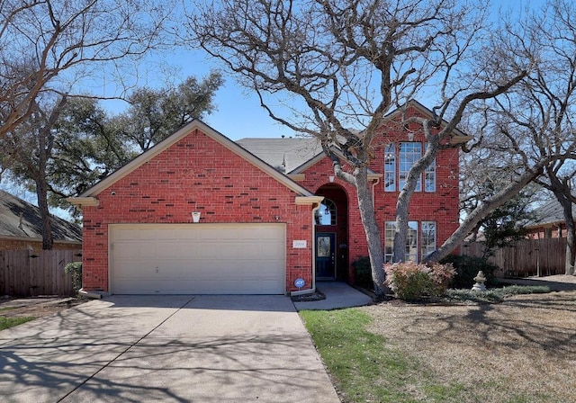 traditional-style home with concrete driveway, brick siding, fence, and an attached garage