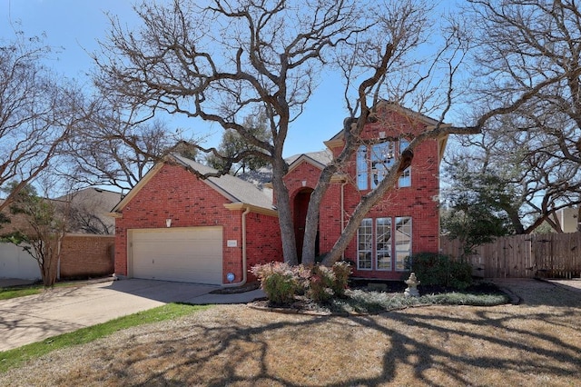 traditional-style house with an attached garage, fence, concrete driveway, and brick siding