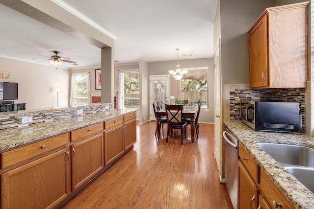 kitchen featuring dishwasher, light wood-type flooring, backsplash, and brown cabinets