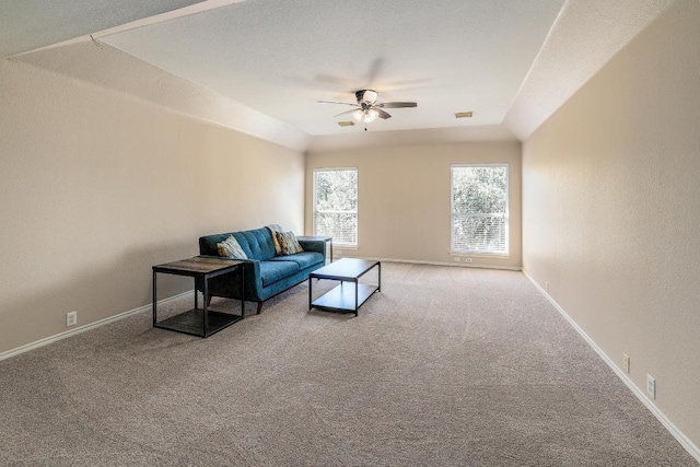 carpeted living room with visible vents, lofted ceiling, a ceiling fan, and baseboards