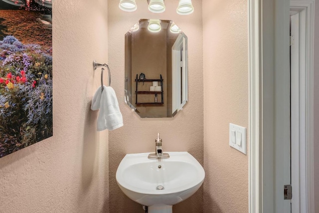 bathroom featuring a textured wall and a sink