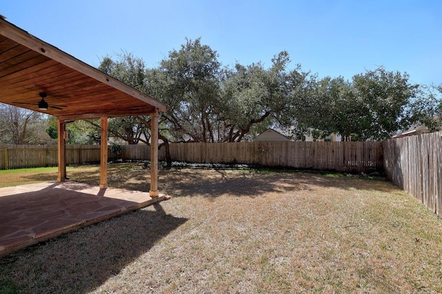 view of yard featuring a ceiling fan, a patio area, and a fenced backyard